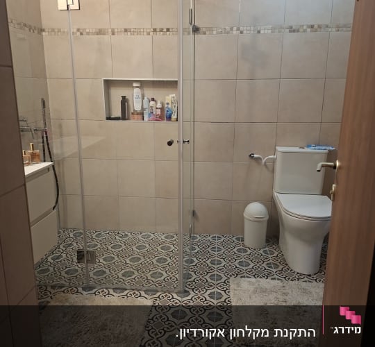 חדר אמבטיה עם מקלחון זכוכית ורצפת אריחים מעוצבת